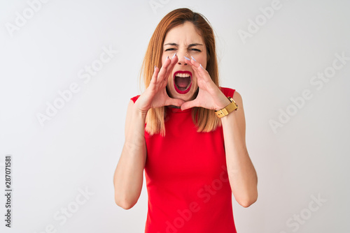 Redhead businesswoman wearing elegant red dress standing over isolated white background Shouting angry out loud with hands over mouth