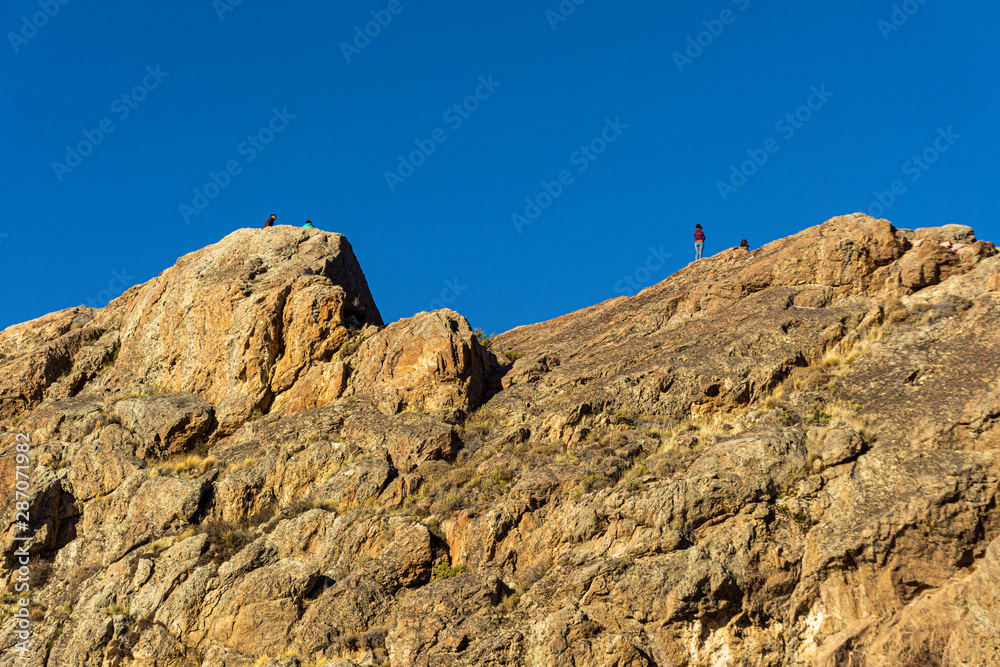 Scene view of mountain climbers reaching mountain peak against snow-capped Andes mountains in Patagonia, Esquel, Argentina Scene view of mountain climbers reaching mountain peak against snow-capped Andes mountains in Patagonia, Esquel, Argentina