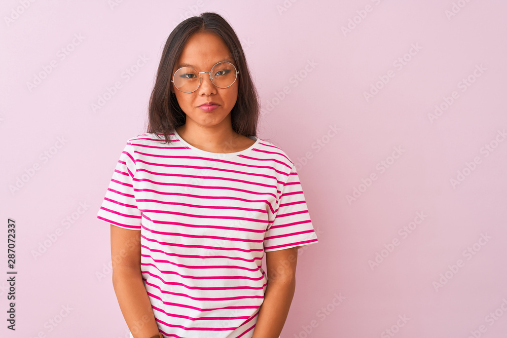 Young chinese woman wearing striped t-shirt and glasses over isolated pink background depressed and worry for distress, crying angry and afraid. Sad expression. Young chinese woman wearing striped t-shirt and glasses over isolated pink background depressed and worry for distress, crying angry and afraid. Sad expression.