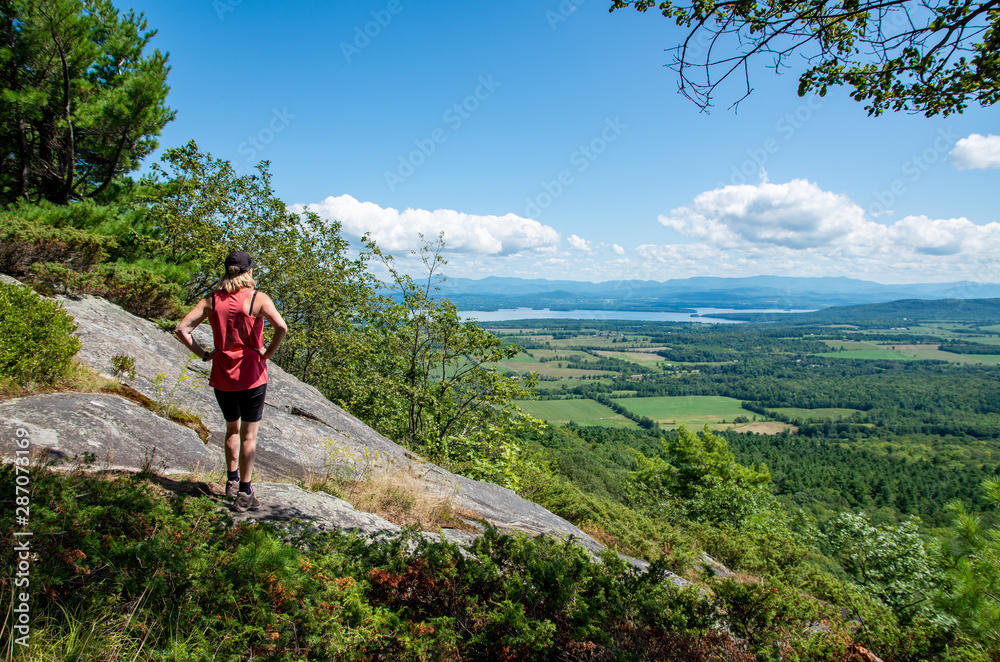 woman taking in the view from Boquet mountain trail