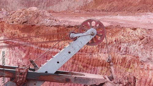 A huge bucket of a large mining excavator is gaining bauxite. Top view, close up.
