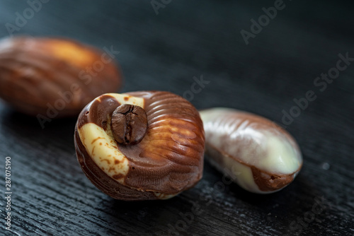 Belgian chocolates on a black wooden background. Photographed close-up.