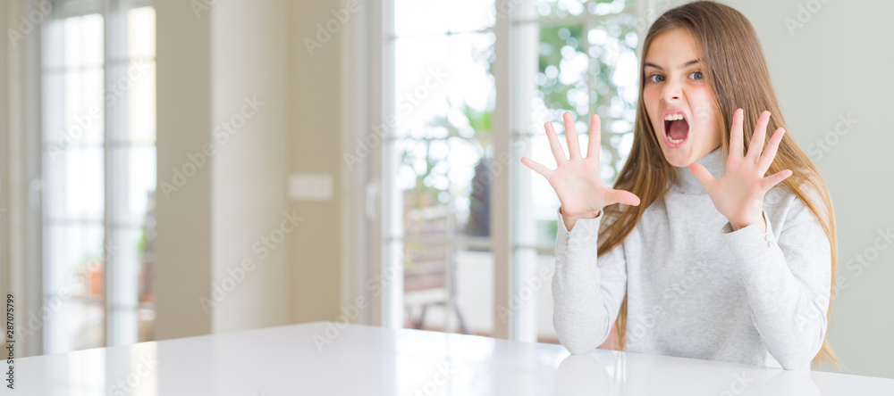 Wide angle picture of beautiful young girl kid wearing casual sweater afraid and terrified with fear expression stop gesture with hands, shouting in shock. Panic concept. Wide angle picture of beautiful young girl kid wearing casual sweater afraid and terrified with fear expression stop gesture with hands, shouting in shock. Panic concept.