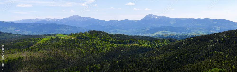 Panorama of  Carpathians countryside. Wonderful summer time landscape in mountains. Grassy field and rolling hills. Rural scenery