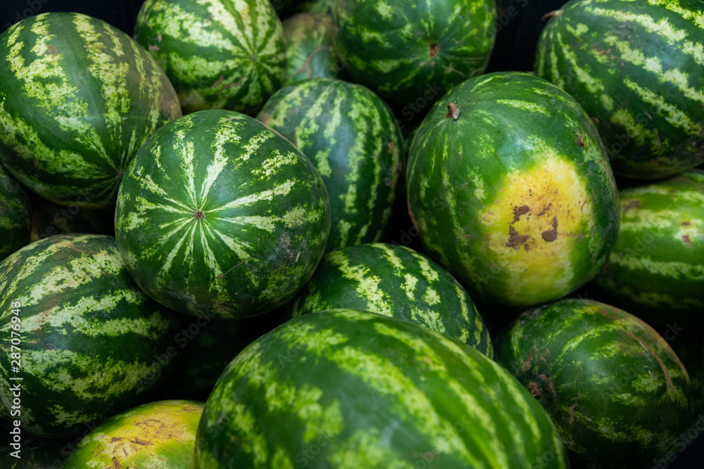 Striped ripe watermelon background ar farmer's market or grocery store. Harvest illustration photo. Striped ripe watermelon background ar farmer's market or grocery store. Harvest illustration photo.