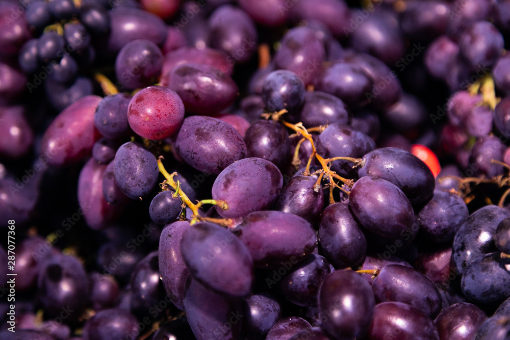 Delicious fragrant exotic berry close-up, black grape background