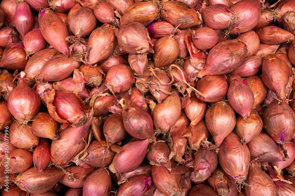 Raw spicy red shallots background, aerial view Raw spicy red shallots background, aerial view