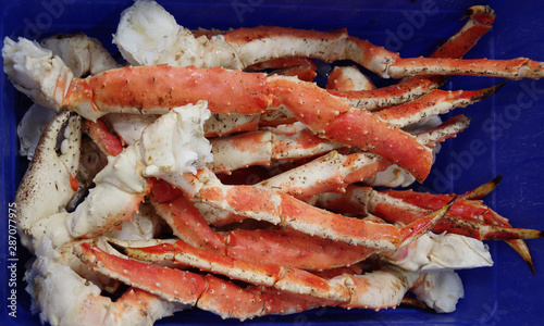 Close-up full frame view of king crab legs in a blue container to be displayed at a market stand