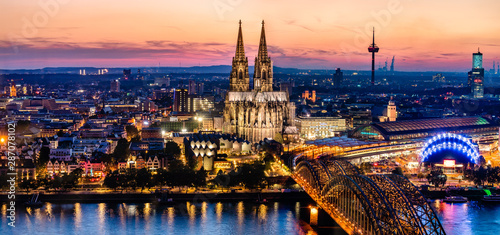 Beautiful night landscape of the gothic Cologne cathedral, Hohenzollern Bridge and the River Rhine at sunset and blue hour in Cologne, Germany photo