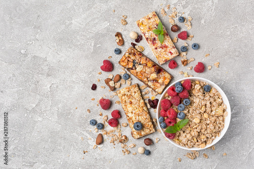 Oat flakes with fresh berries and granola bar for healthy breakfast