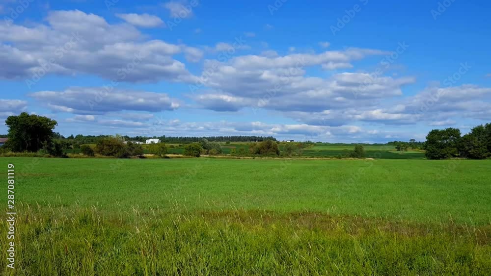 Camera Panning Overlooking Rural Fields in the Countryside in the Day. Beautiful Scenic Landscape Nature in the Country During Bright Daytime. Camera Panning Overlooking Rural Fields in the Countryside in the Day. Beautiful Scenic Landscape Nature in the Country During Bright Daytime.