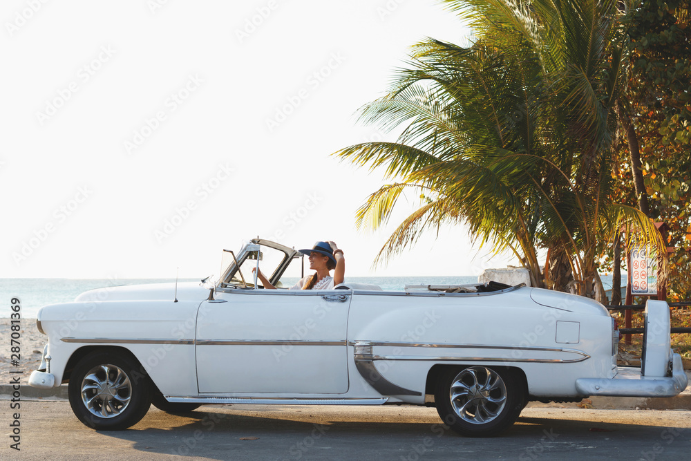 Happy young woman and retro convertible car - obrazy, fototapety, plakaty 