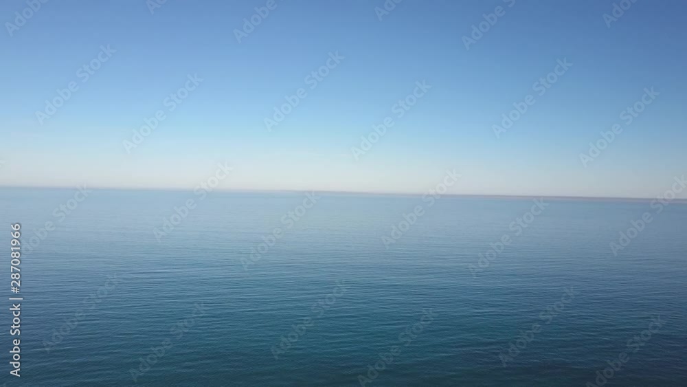 Aerial view of drone flight above calm and tranquil turquoise ocean water, smooth shimmering surface as backdrop or wallpaper. Aerial view of drone flight above calm and tranquil turquoise ocean water, smooth shimmering surface as backdrop or wallpaper.