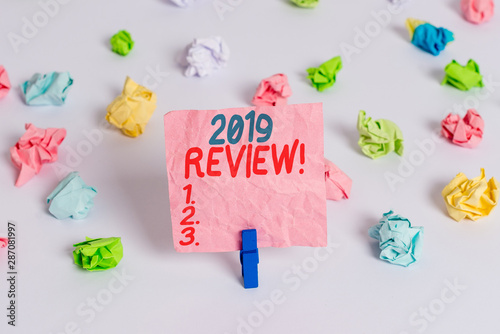 Conceptual hand writing showing 2019 Review. Concept meaning remembering past year events main actions or good shows Colored crumpled paper empty reminder white floor clothespin