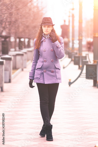 Beautiful girl in a hat, walking down the street.