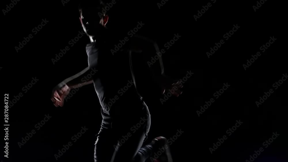 Young Man Break Dancing Against in black studio. Slow motion. Close up. Young Man Break Dancing Against in black studio. Slow motion. Close up.