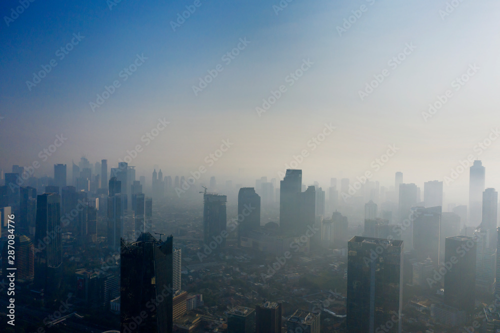 Residential houses and skyscrapers with air pollution