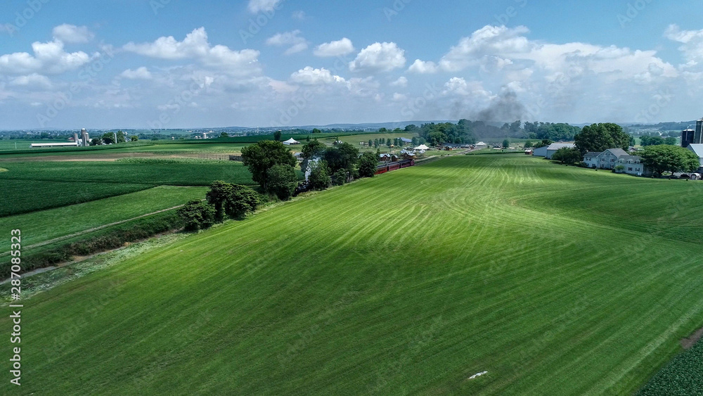 Aerial View of a Steam Train Arriving in Amish Countryside