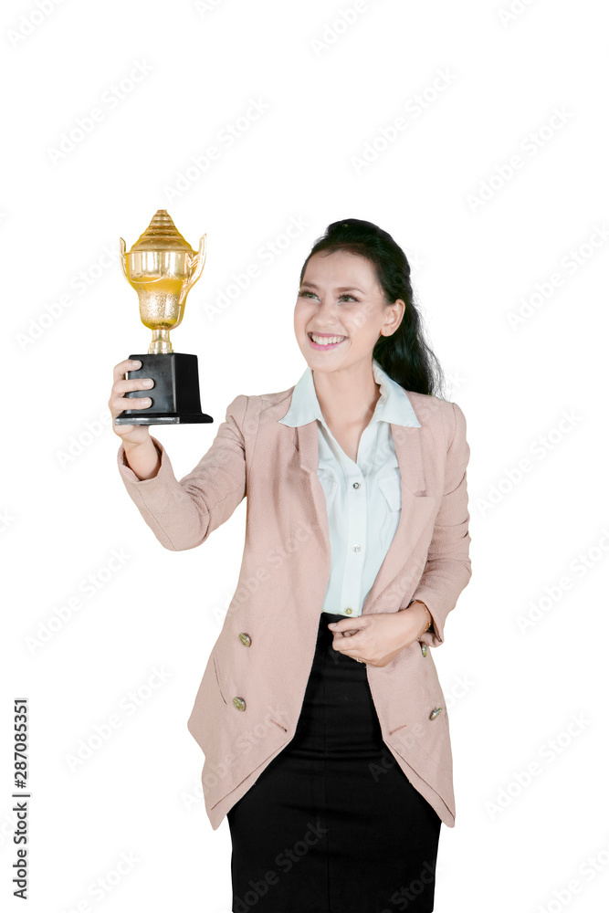 Smiling businesswoman holding a trophy on studio Smiling businesswoman holding a trophy on studio