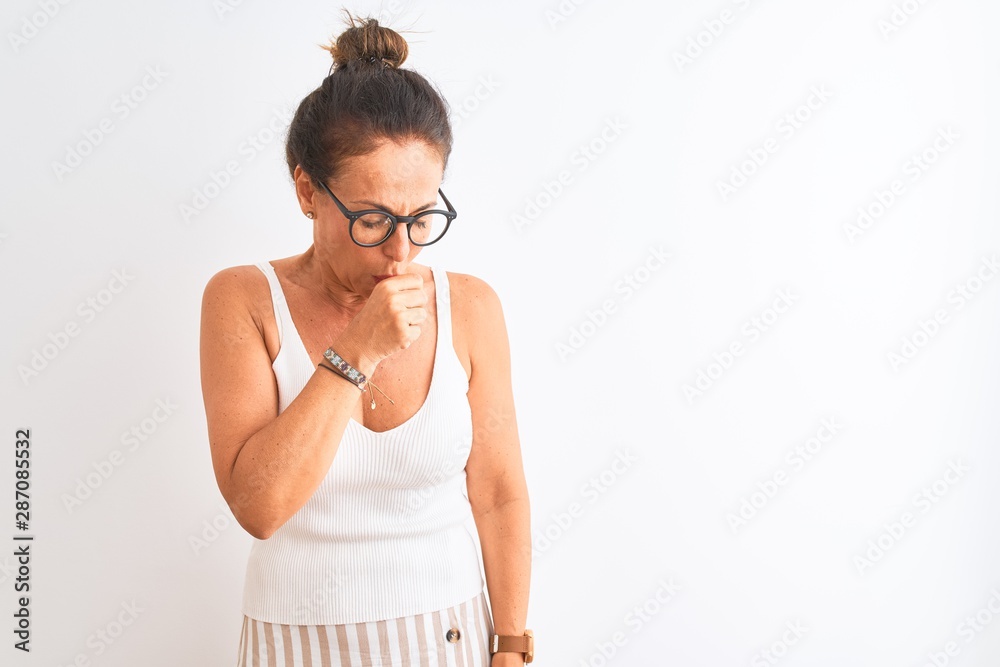 Middle age woman wearing casual t-shirt and glasses standing over isolated white background feeling unwell and coughing as symptom for cold or bronchitis. Healthcare concept.