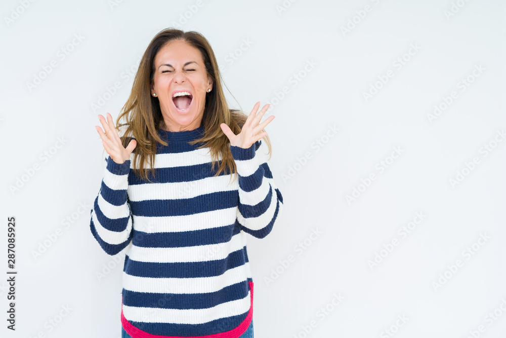 Beautiful middle age woman wearing navy sweater over isolated background celebrating mad and crazy for success with arms raised and closed eyes screaming excited. Winner concept Beautiful middle age woman wearing navy sweater over isolated background celebrating mad and crazy for success with arms raised and closed eyes screaming excited. Winner concept
