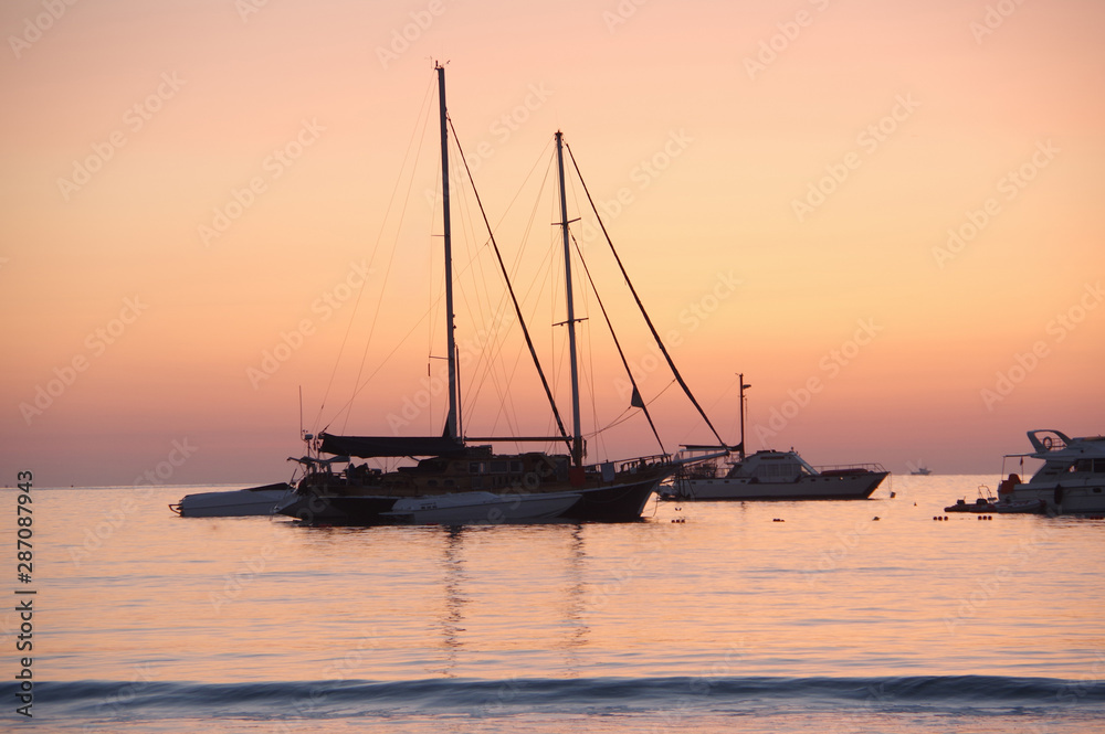 Purple dawning. Yachts in the sea during sunrise