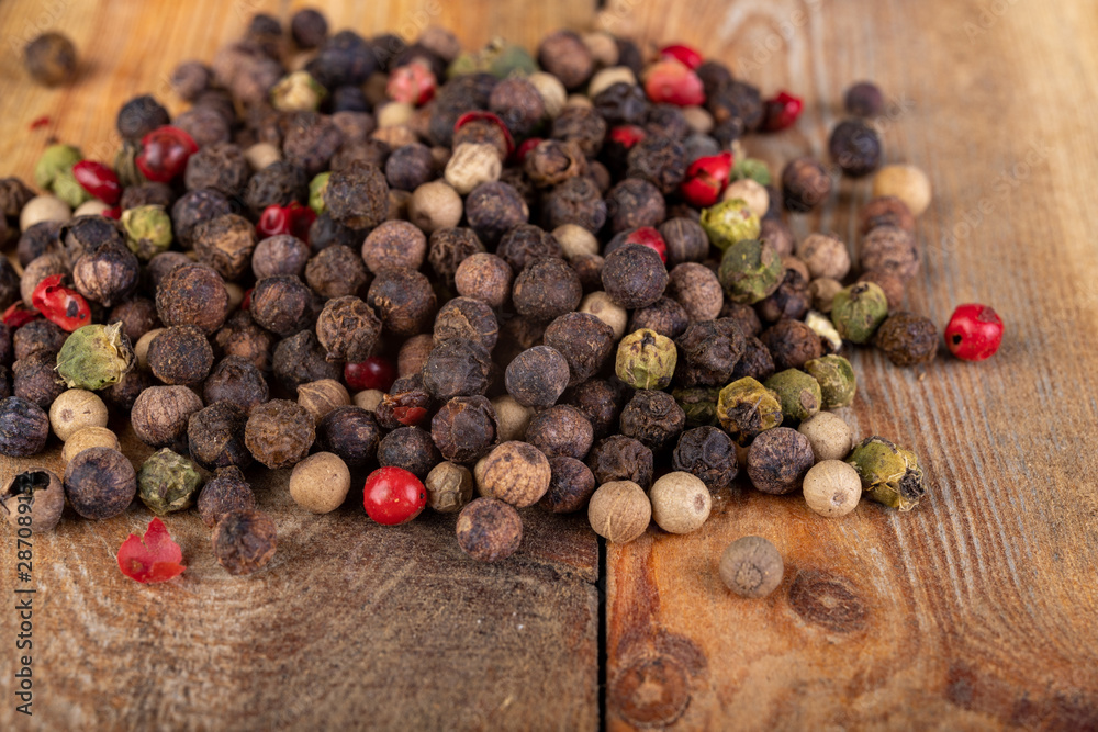 Tasty colorful pepper on a wooden kitchen table. Fresh spices used in home cooking. Tasty colorful pepper on a wooden kitchen table. Fresh spices used in home cooking.