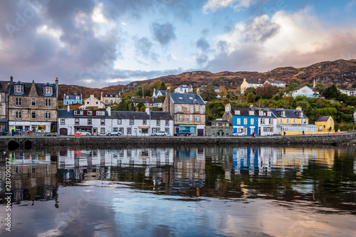 Still water of Tarbert Harbour reflect the beautifully painted houses on Barmore Rd in Argyll and Bute Scotland United Kingdom photo