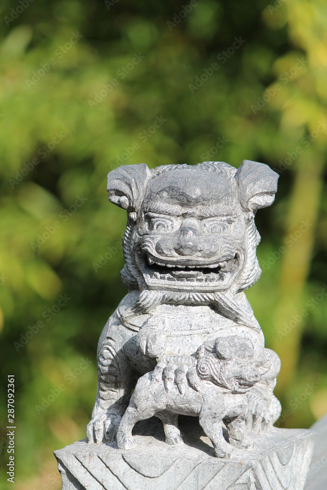 Beautiful chinese Guardian Lion Statue with Cub in a chinese garden