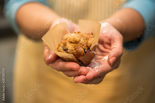 Woman holding a blueberry muffin