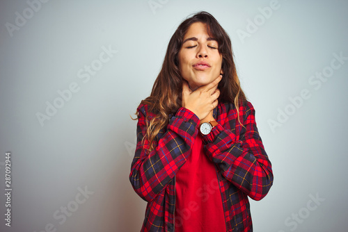 Young beautiful woman wearing red t-shirt and jacket standing over white isolated background shouting and suffocate because painful strangle. Health problem. Asphyxiate and suicide concept. © Krakenimages.com