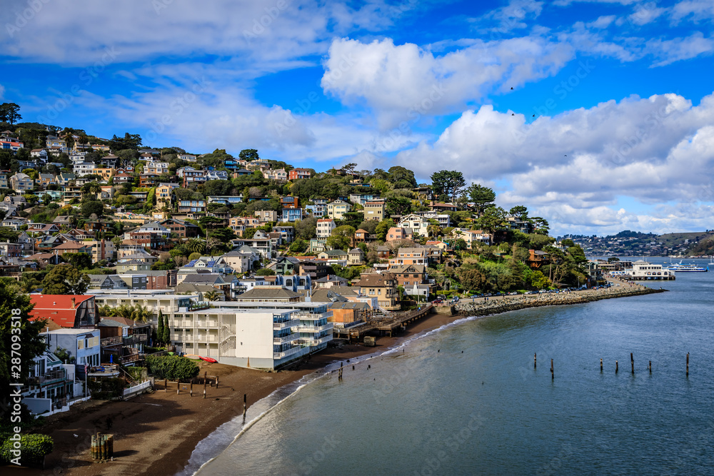 Idyllic view of the south end of Sausalito waterfront on a very clear sunny day with fluffy clouds and a few birds