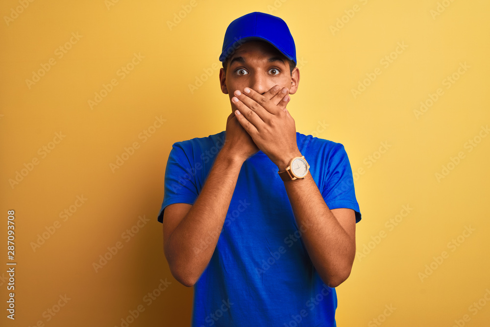Young handsome arab delivery man standing over isolated yellow background shocked covering mouth with hands for mistake. Secret concept. Young handsome arab delivery man standing over isolated yellow background shocked covering mouth with hands for mistake. Secret concept.