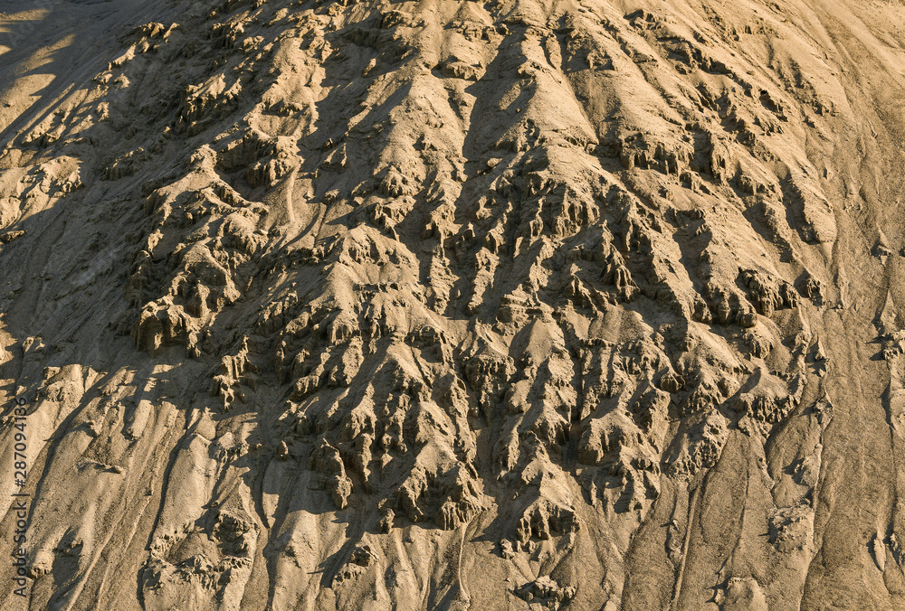 crumbling sand from the slope of a sandy hill. crumbling sand from the slope of a sandy hill.
