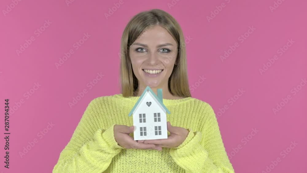 Beautiful Young Girl holding Model House, Pink Background Beautiful Young Girl holding Model House, Pink Background