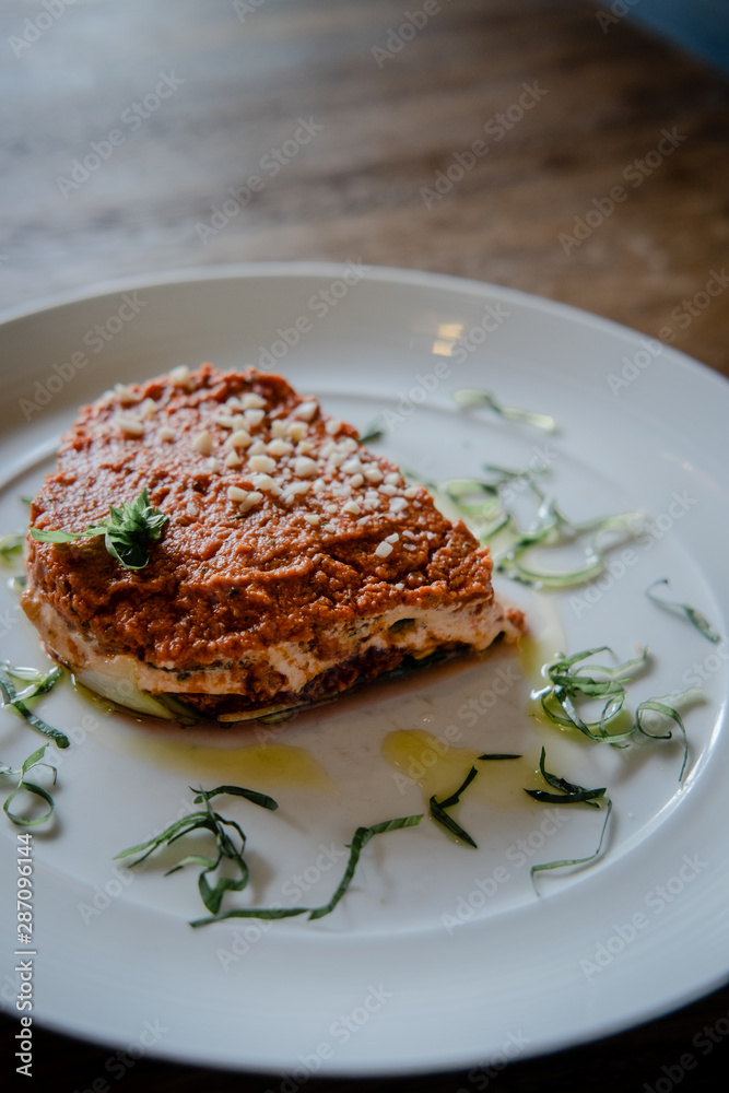 Raw vegan lasagna on a white plate. Dairy free, gluten free food. Raw vegan lasagna on a white plate. Dairy free, gluten free food.