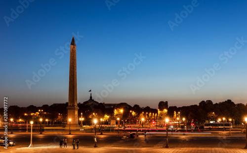 Traffic on Place de la Concorde at night with Obelisk of Luxor and Grand Palais in background - Paris, France