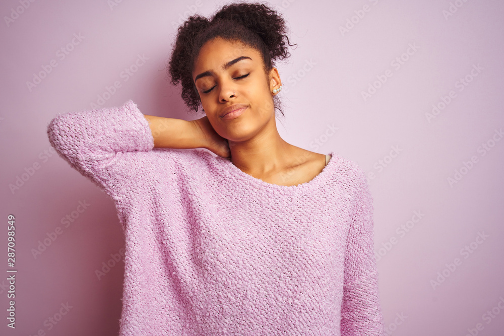 Young african american woman wearing winter sweater standing over isolated pink background Suffering of neck ache injury, touching neck with hand, muscular pain Young african american woman wearing winter sweater standing over isolated pink background Suffering of neck ache injury, touching neck with hand, muscular pain
