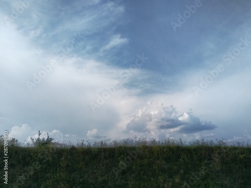 storm clouds over green field