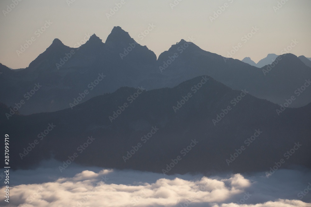 Mountain layers tower above morning fog 