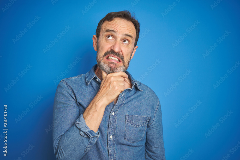 Handsome middle age senior man with grey hair over isolated blue background Thinking worried about a question, concerned and nervous with hand on chin Handsome middle age senior man with grey hair over isolated blue background Thinking worried about a question, concerned and nervous with hand on chin