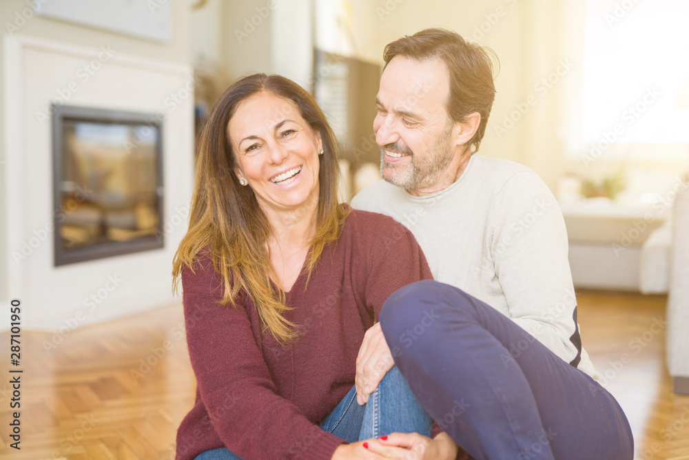 Beautiful romantic couple sitting together on the floor at home Beautiful romantic couple sitting together on the floor at home