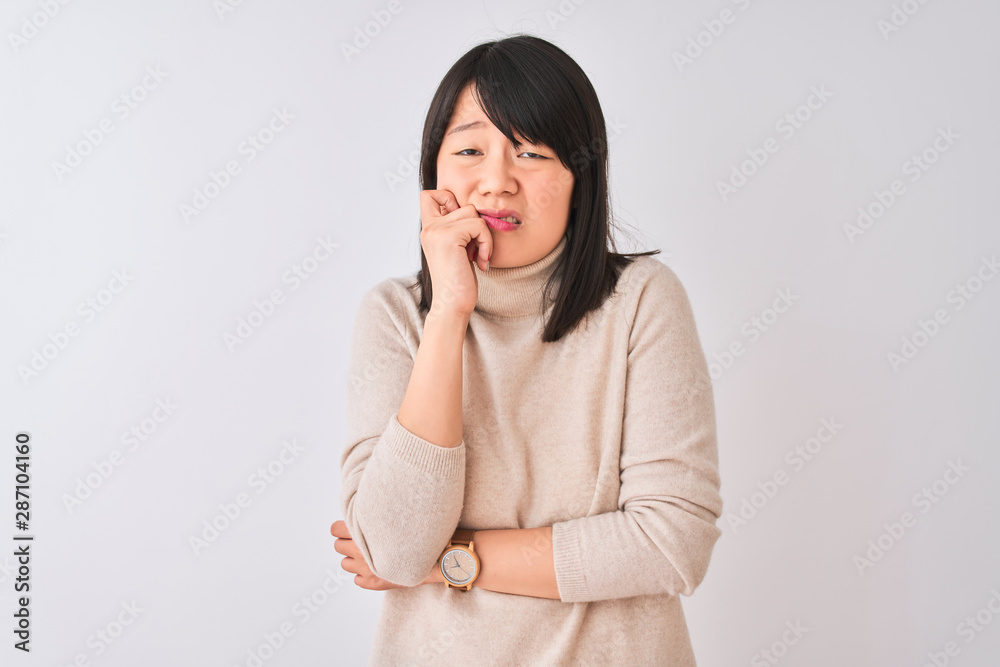 Young beautiful chinese woman wearing turtleneck sweater over isolated white background looking stressed and nervous with hands on mouth biting nails. Anxiety problem. Young beautiful chinese woman wearing turtleneck sweater over isolated white background looking stressed and nervous with hands on mouth biting nails. Anxiety problem.