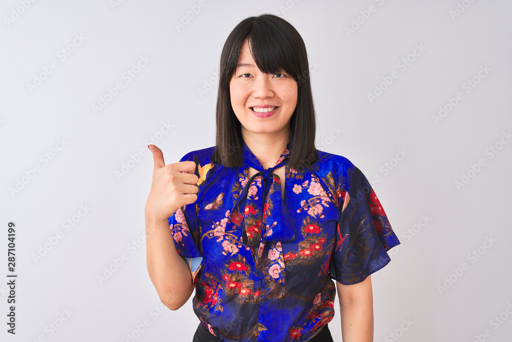 Young beautiful chinese woman wearing summer floral t-shirt over isolated white background doing happy thumbs up gesture with hand. Approving expression looking at the camera showing success. Young beautiful chinese woman wearing summer floral t-shirt over isolated white background doing happy thumbs up gesture with hand. Approving expression looking at the camera showing success.