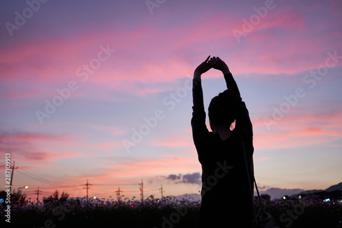 A woman stretching and looking at the sunset sky of Jechun, South Korea. photo