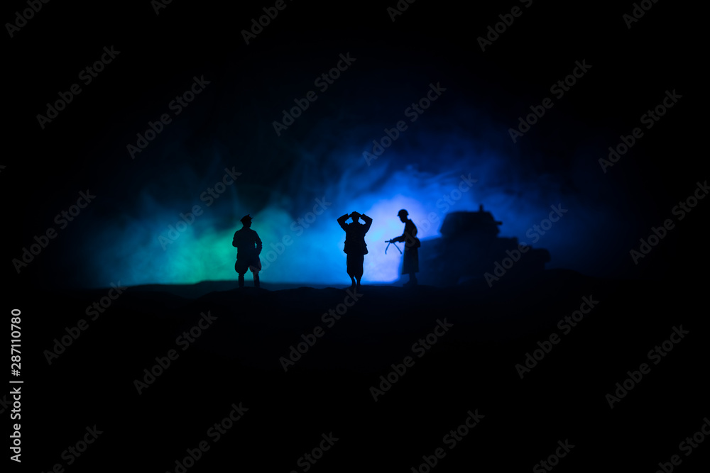 Fototapeta premium Battle scene. Military silhouettes fighting scene on war fog sky background. A German soldiers raised arms to surrender. Plastic toy soldiers with guns taking prisoner the enemy soldier.