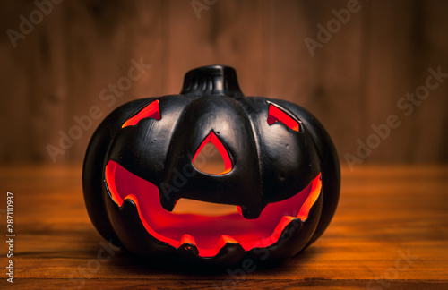 Black halowwen pumpkin on wooden background / Haloween background concept with jack-o-lantern photo