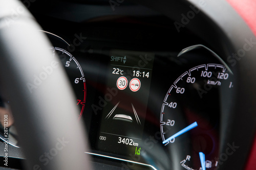Modern car dashboard with speed limit and overtaking signs