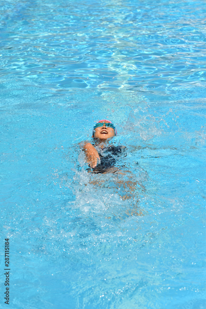 プールで泳ぐ女の子（背泳ぎ）