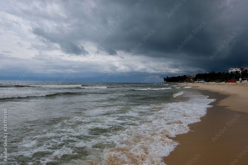 perspective coastline in Mui Ne Vietnam. cloudy dark stormy sky. Wide ocean waves